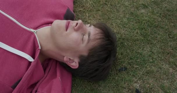 Widok przystojnego mężczyzny drzemie na trawie — Wideo stockowe