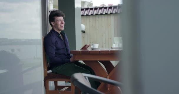 Mężczyzna z dmuchanie hairstyle trzymając tablet, śmiejąc się i radując z wygranej — Wideo stockowe
