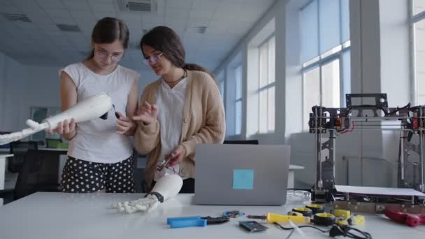Gadis di kelas menghubungkan tangan 3D dicetak ke papan sirkuit — Stok Video