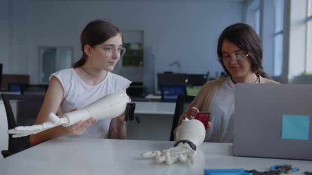 Les filles regardent l'écran des ordinateurs portables et connectent la main imprimée en 3D — Video