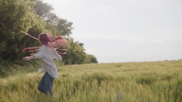 Fille avec de longs cheveux rouges et dans des lunettes se retournant — Video