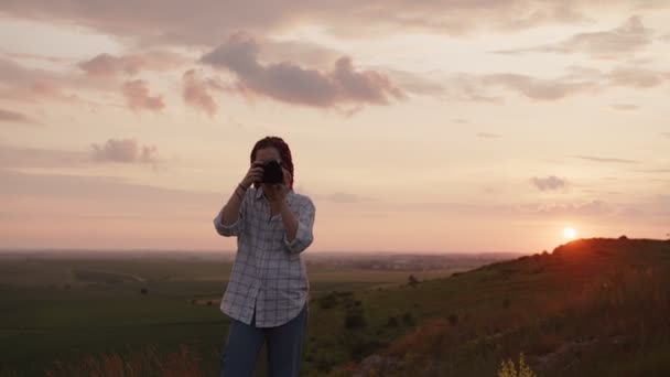 Mosolygó lány lövöldözik a fekete fényképezőgépén — Stock videók