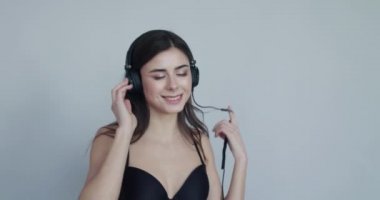 Kız kulaklıkla müzik dinliyor, flört ediyor, kulaklıkları çeviriyor.