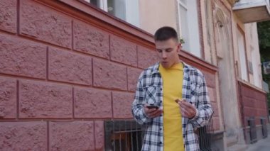 Sarı giyen adam kırmızı arka planda yemek yiyor.