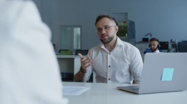 Genç adam ortağıyla iş hakkında konuşuyor.