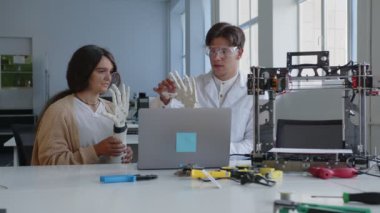 Öğretmenler öğrenciye 3D yazıcıların nasıl çalıştığını anlatıyor.