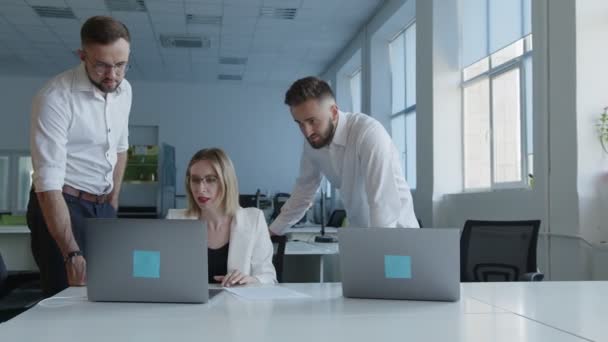 Fille explique le travail en ligne sur ordinateur portable à ses collègues — Video