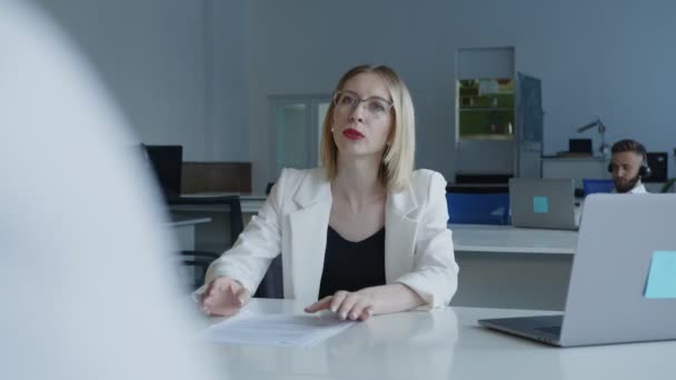 Mulher bonita fala com seu colega de trabalho em um escritório — Vídeo de Stock
