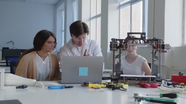 Profesor en gafas blancas muestra cómo utilizar y cómo trabajar con la impresora 3D — Vídeo de stock