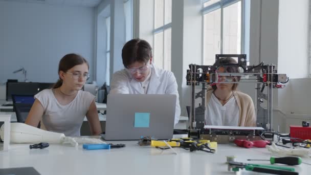 El profesor muestra cómo conectar el portátil con la impresora 3D — Vídeo de stock