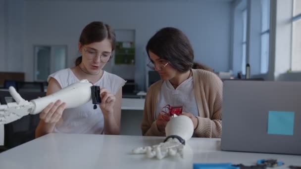 여자 아이들은 3D 로 인쇄 된 손을 주의 깊이 바라본다 — 비디오