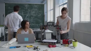Okullu kızların laboratuarda ortak çalışması, fen dersi.