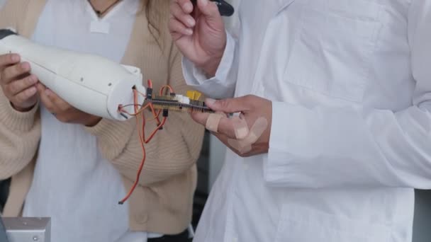 Close up girls and techers hands with 3D printed hand — Stock Video