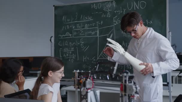 Учитель открывает свои знания о трехмерной печатной руке — стоковое видео