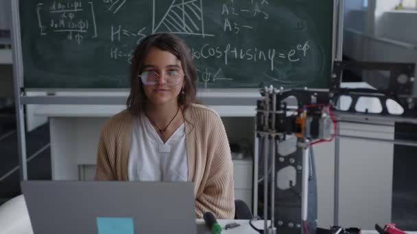 Молода школярка сидить біля 3D принтера — стокове відео