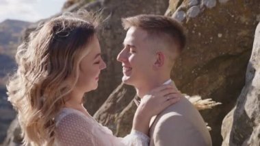 Gelin ve damat kayalık dağ tepelerinde. Düğün çifti. Yakın plan çekim. Yavaş çekim