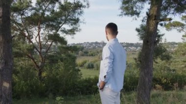 Parktaki yakışıklı bir adam. Pozitif gülümseyen adamın profil portresi.