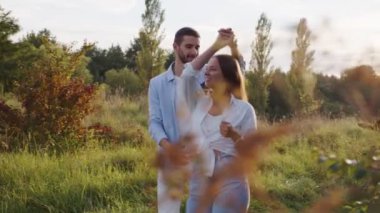 Romantik komik çift parkta yürüyor. Mutlu gülümseyen erkek ve kadının portresi, yazları açık havada vakit geçirmek..