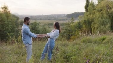 Parkta sarılan güzel bir kız ve oğlan. Genç aşıklar gülümsüyor ve anın tadını çıkarıyorlar..