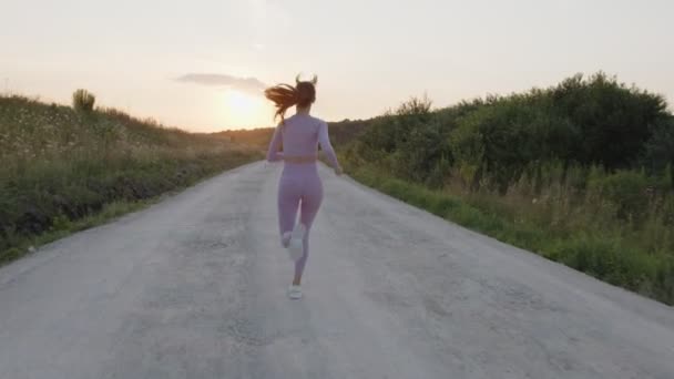 Powrót widok młodej damy, która biegnie po drodze — Wideo stockowe