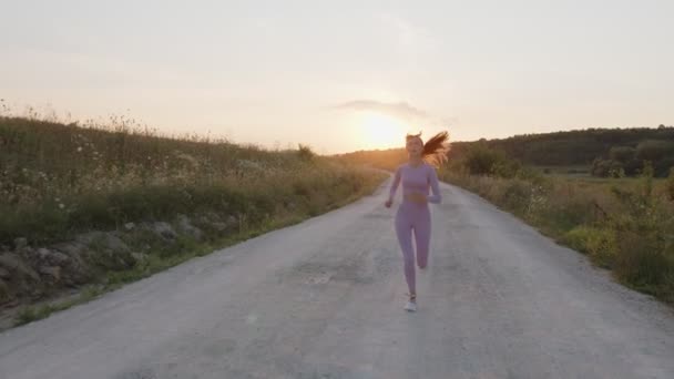 Убежденная юная леди бегает по дороге в спортивном костюме — стоковое видео