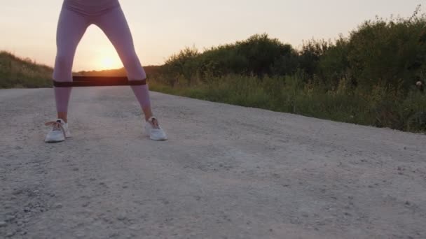 Blick auf goldene Beine mit schwarzem Gummizug — Stockvideo