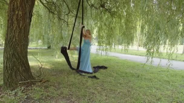 Geconcentreerd jong meisje in blauwe jurk toont haar vaardigheden — Stockvideo