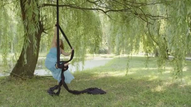 Pohled na dívku, která dělá nějaké frexible pohyby na leteckém hedvábí — Stock video