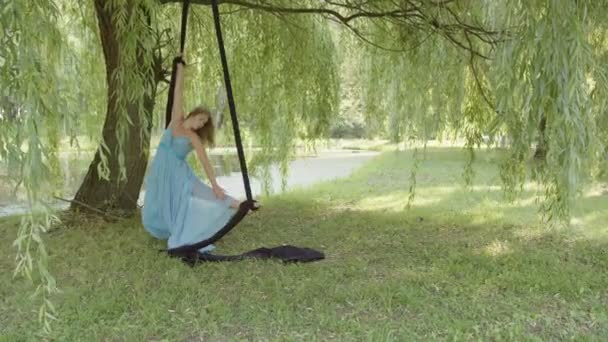 Pemandangan seorang gadis dengan gaun biru yang memegang sutra udara — Stok Video