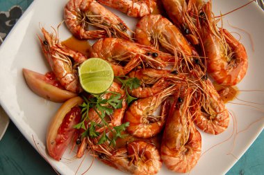 Yeşil limonlu ızgara karides, maydanoz ve doğranmış domates..