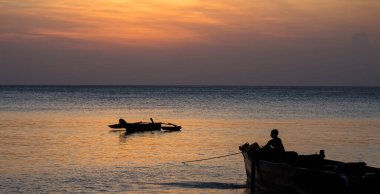 Teknede bir çocuk Zanzibar 'da gün batımına bakıyor. Tanzanya 'da. Afrika