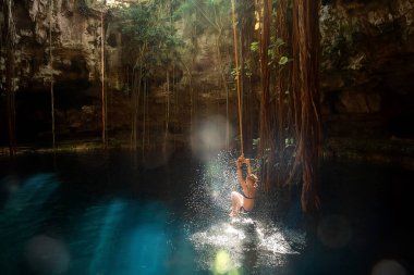  Bungee 'deki kız. Cenote Ik-Kil Yucatan. Meksika.
