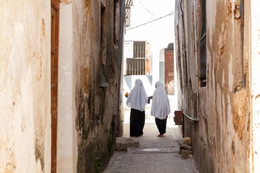 African girls in traditional clothes on the narrow street of Stone Town. Zanzibar