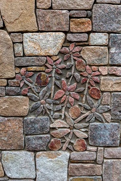 Stone wall texture Flowers laid out of stone on a stone wall.