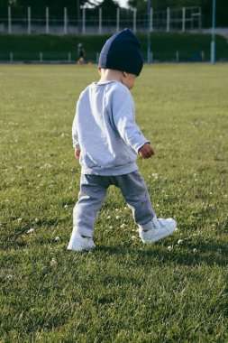 Çocuk stadyumun etrafında koşuyor.