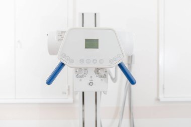Modern hastanenin röntgen bölümü. Boş yataklı tarama makineli radyoloji odası. Teknisyen röntgen cihazını ayarlıyor. Modern klinikte göğüs, kalp ve akciğerler taranıyor.