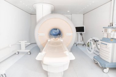 Modern hastane laboratuvarında tıbbi tomografi ya da MRI taraması. Radyografi bölümünün içi. Beyaz odada teknolojik olarak gelişmiş ekipmanlar var. Manyetik rezonans tanılama makinesi