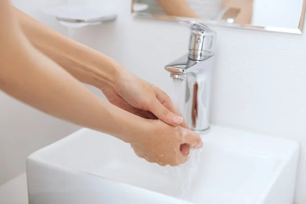 Hände waschen unter dem fließenden Wasserhahn. Händewaschen mit Seife zur Vorbeugung des Coronavirus, Hygiene gegen die Ausbreitung des Coronavirus in öffentlichen Waschräumen. Hygienekonzept Hand in Hand — Stockfoto