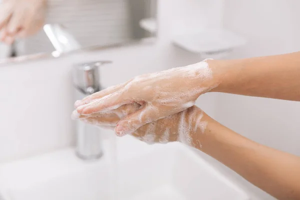 Πλένεις τα χέρια σου κάτω από τη βρύση. Πλύσιμο χεριών τρίψιμο με σαπούνι για την πρόληψη του ιού του στέμματος, υγιεινή για να σταματήσει η εξάπλωση του ιού του στέμματος στο δωμάτιο ή δημόσια πλύση. Στοιχεία του χεριού έννοιας της υγιεινής — Φωτογραφία Αρχείου