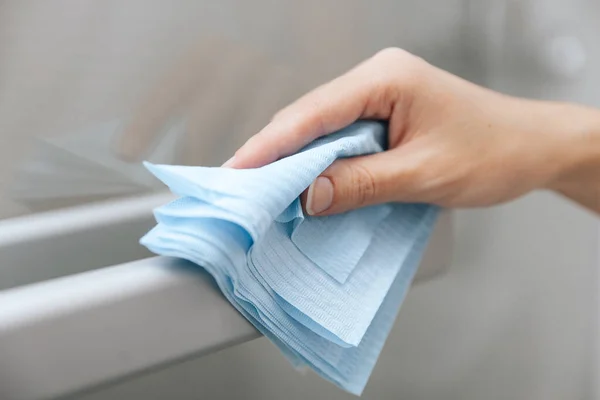 用防腐剂湿擦拭清洗玻璃门把手.女人用毛巾清洁家房间的门链.在医院和公共场所清洁表面，防止感染日冕病毒 — 图库照片