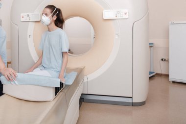 Modern hastane laboratuvarında bir hastaya tıbbi tomografi ya da MRI taraması yapın. Radyografi bölümünün içi. Beyaz odada teknolojik olarak gelişmiş ekipmanlar var. Manyetik rezonans tanılama makinesi