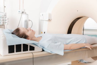 Modern hastane laboratuvarında bir hastaya tıbbi tomografi ya da MRI taraması yapın. Radyografi bölümünün içi. Beyaz odada teknolojik olarak gelişmiş ekipmanlar var. Manyetik rezonans tanılama makinesi