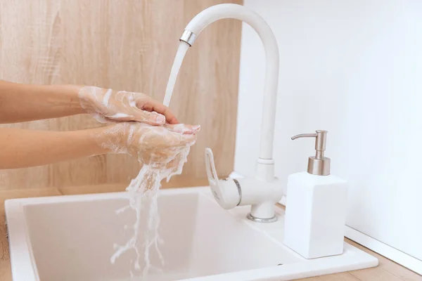 Lavarse las manos bajo el grifo de agua corriente. Lavarse las manos frotándose con jabón para la prevención del virus de la corona, higiene para dejar de propagar el virus de la corona en el baño público o. Concepto de higiene detalle de la mano — Foto de Stock