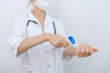 Sıcaklık ölçüm silahı doktorun elinde. Doktorun koruyucu cerrahi maske takıp vücut ısısını kontrol etmek için kızılötesi izometrik termometre tabancası kullanmaya hazır olduğu yakın çekim.