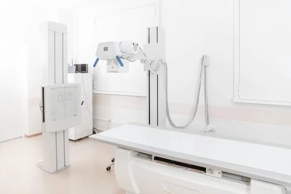 Dział rentgenowski w nowoczesnym szpitalu. Pokój radiologiczny z skanerem z pustym łóżkiem. Technik dopasowuje rentgen. Skanowanie klatki piersiowej, serca, płuc w nowoczesnym gabinecie kliniki — Zdjęcie stockowe