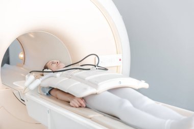 Modern hastane laboratuvarında bir hastaya tıbbi tomografi ya da MRI taraması yapın. Radyografi bölümünün içi. Beyaz odada teknolojik olarak gelişmiş ekipmanlar var. Manyetik rezonans tanılama makinesi