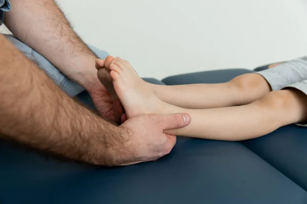 Knee pain relief in clinic. Doctor physiotherapist doing healing treatment on patient leg. Therapist giving leg and calf massage. Osteopathy, Chiropractic leg adjustment. Chiropractic treatment
