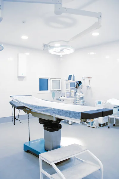 'δειο χειρουργείο σε νοσοκομείο. Χειρουργικός εξοπλισμός με χειρουργικό τραπέζι. Ιατρική συσκευή για επείγουσα ασθενή σε μπλε ύφος. Κενά Επείγοντα Χειρουργεία. Εσωτερικό κλινικής για φόντο — Φωτογραφία Αρχείου