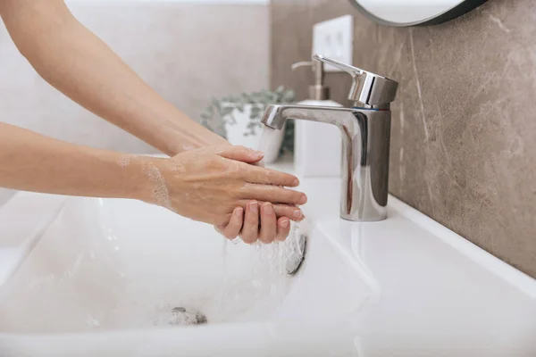 Handen wassen onder de stromende kraan. Hygiëne concept hand detail. Handen wassen wrijven met zeep voor preventie van corona virus, hygiëne om te stoppen met het verspreiden van corona virus in of openbare wasruimte — Stockfoto