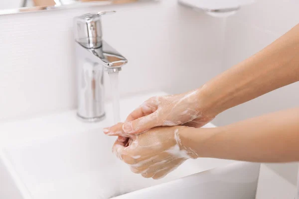 Handen wassen onder de stromende kraan. Handen wassen wrijven met zeep voor preventie van corona virus, hygiëne om te stoppen met het verspreiden van corona virus in of openbare wasruimte. Hygiëne concept hand detail — Stockfoto